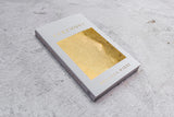 A gold box on a concrete surface with the Ceremony | Brianna Wiest by Thought Catalog.