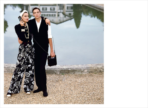 A woman and a man standing next to a Chanel: The Karl Lagerfeld Campaigns book.