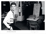 A black and white photo of a man leaning against a Chanel: The Karl Lagerfeld Campaigns book.