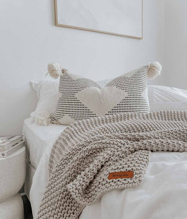 A bed with Bengali Collections' COAST CUSHION COVER and Oeko-tex certified knitted blanket and pure cotton pillows.