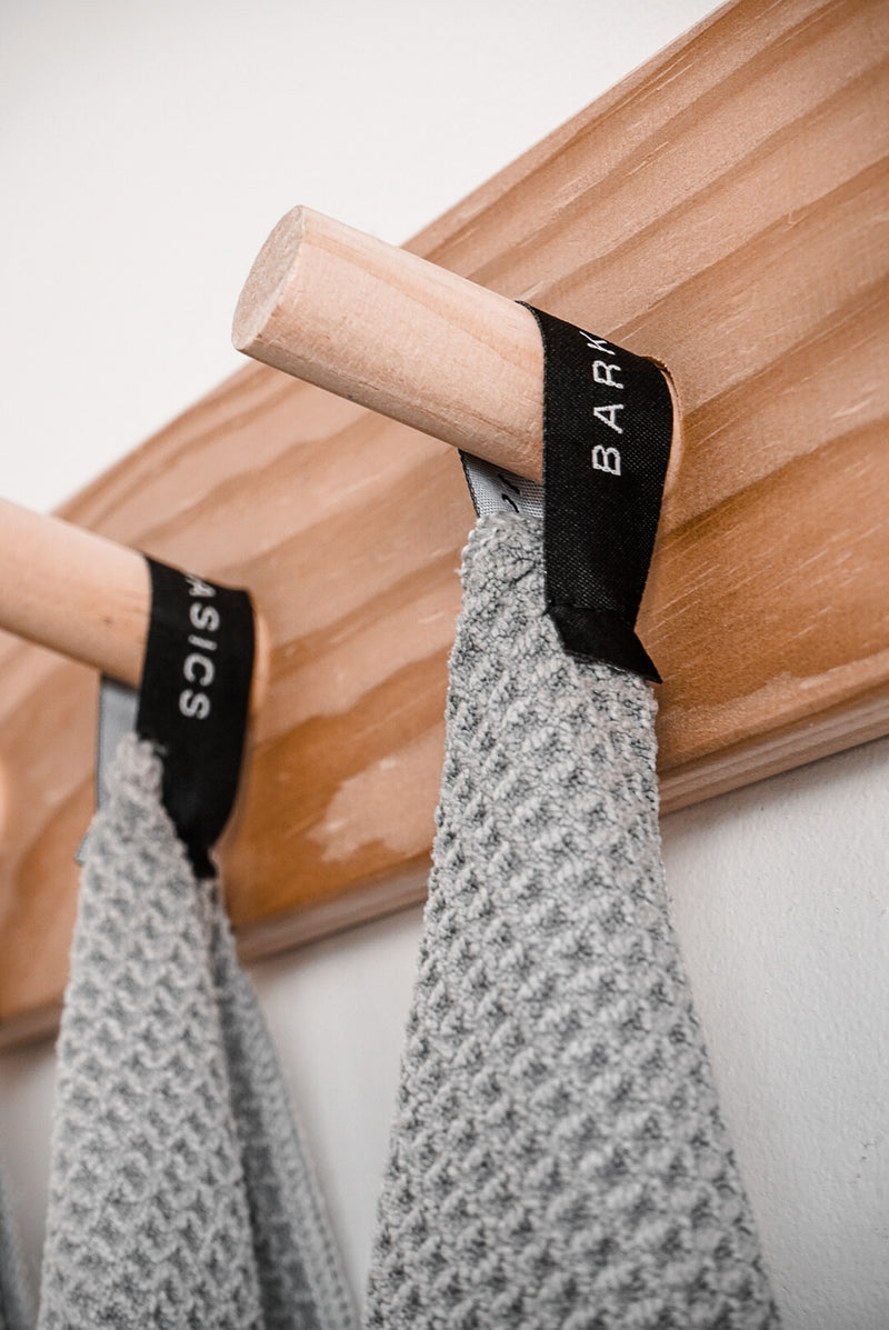 Two Barkly Basics GREY MICROFIBRE TEA TOWELS with a lint-free finish hanging on a wooden rack.