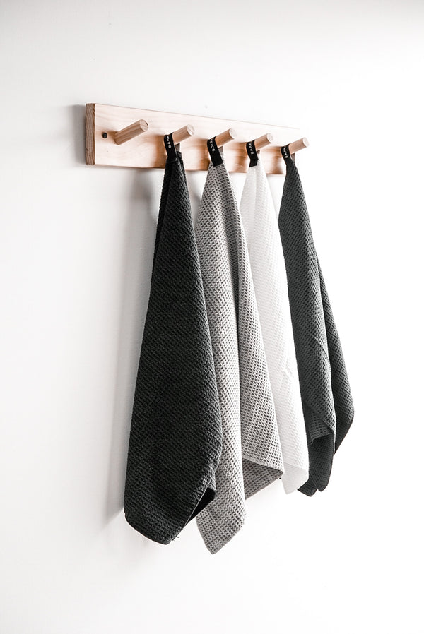 Four Barkly Basics microfiber tea towels hanging on a wooden rack, featuring a lint-free finish and waffle design.