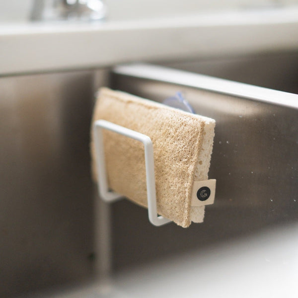 A kitchen sink with a sponge and Good Change ECO SCRUBS 2-PACK hanging from it.