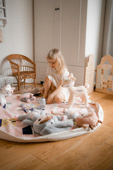 A little girl playing with the Raindrops Village - Interactive from the Play Pouch range in a room.