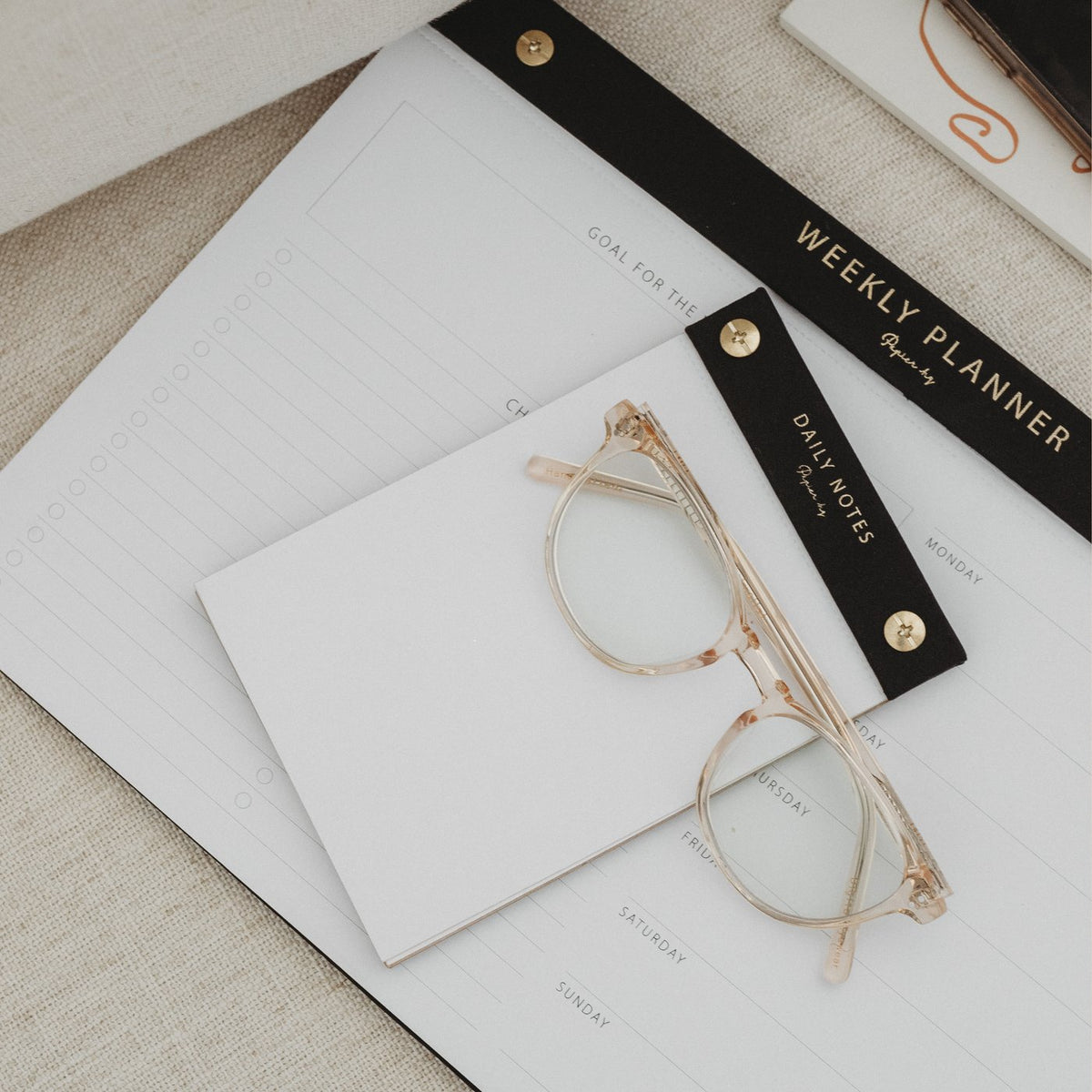 A limited edition Daily notes Papier HQ notebook with a pen and glasses on top.
