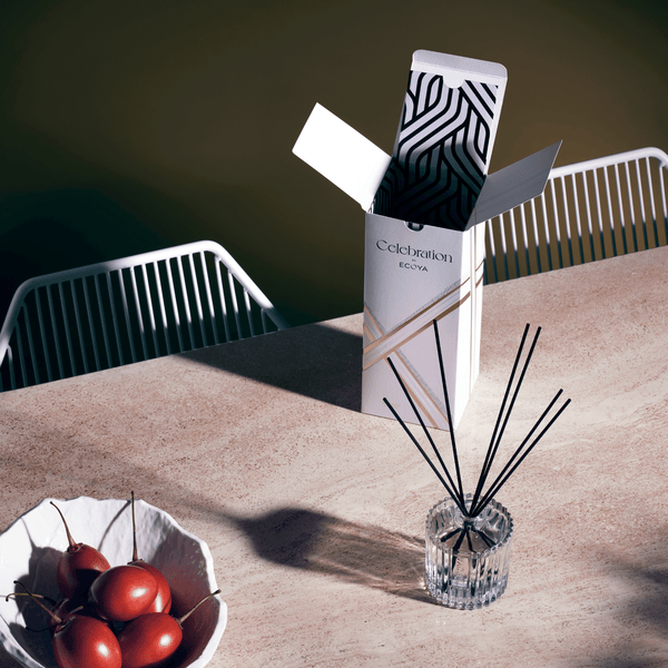 A box of Ecoya Celebration Diffusers sits on a table next to a bowl of tomatoes, adding a touch of home fragrance to the Scandinavian-inspired home design.