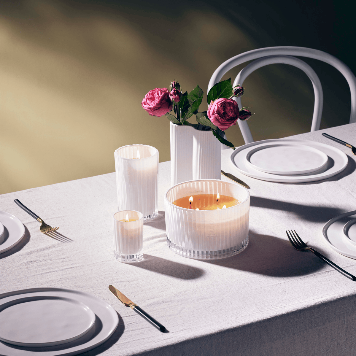 Celebration candle on a table setting with a cup and fresh flowers