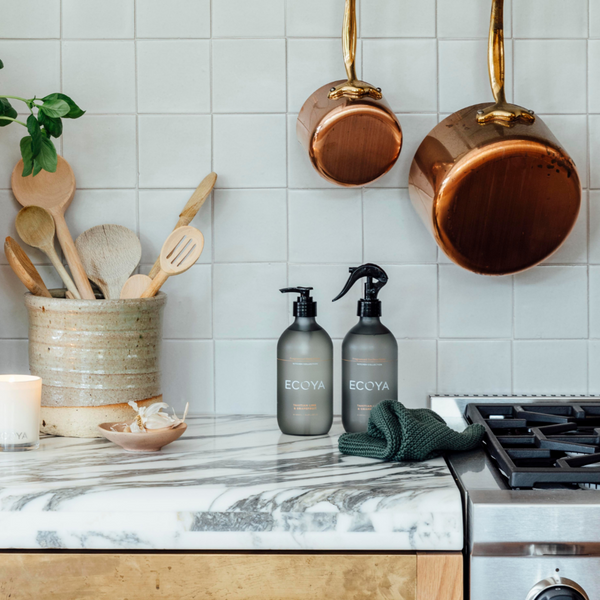 An Ecoya kitchen with a Scandinavian design and fragrant Tahitian Lime & Grapefruit Kitchen Gift Set pots, pans, and utensils.