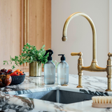 An Ecoya Kitchen with a brass faucet and marble counter top.
