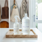 A bottle of Ecoya's Laundry Linen Spray in the scent "Wild Sage & Citrus" is sitting on a wooden tray.