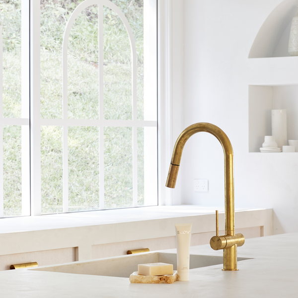 A scandinavian kitchen with a fragranced sink and faucet.