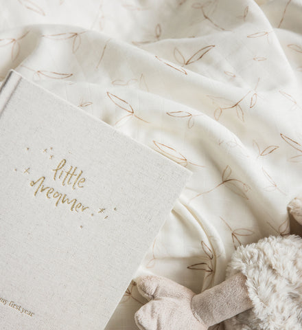 A Baby Swaddle with a teddy bear next to it, made by Emma Kate Co.