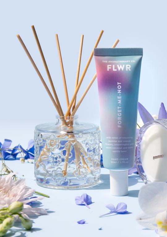 A FLWR Diffuser - FORGET ME NOT by The Aromatherapy Co of orange flowers on a blue background.
