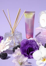 A FLWR Diffuser - Purple Reign by The Aromatherapy Co with blackberries and flowers on a purple background.