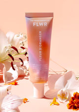 A tube of FLWR Hand Cream - Fleur D'Oranger by The Aromatherapy Co surrounded by flowers.