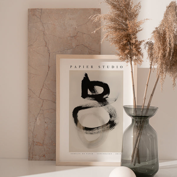 A framed PAPIER HQ | PAPIER STUDIO PRINT of art on a table next to a vase of dandelion.
