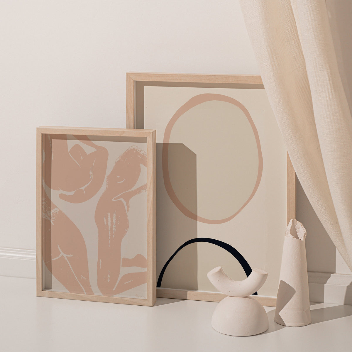 Circles print leaning by a sheer curtain beside white vessels