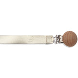 A practical accessory for babies' favorite pacifier - a beige leather strap with a wooden ball on it, perfect for LTL BIG | PACI CLIP IN GOLDIE by Ltl Big.
