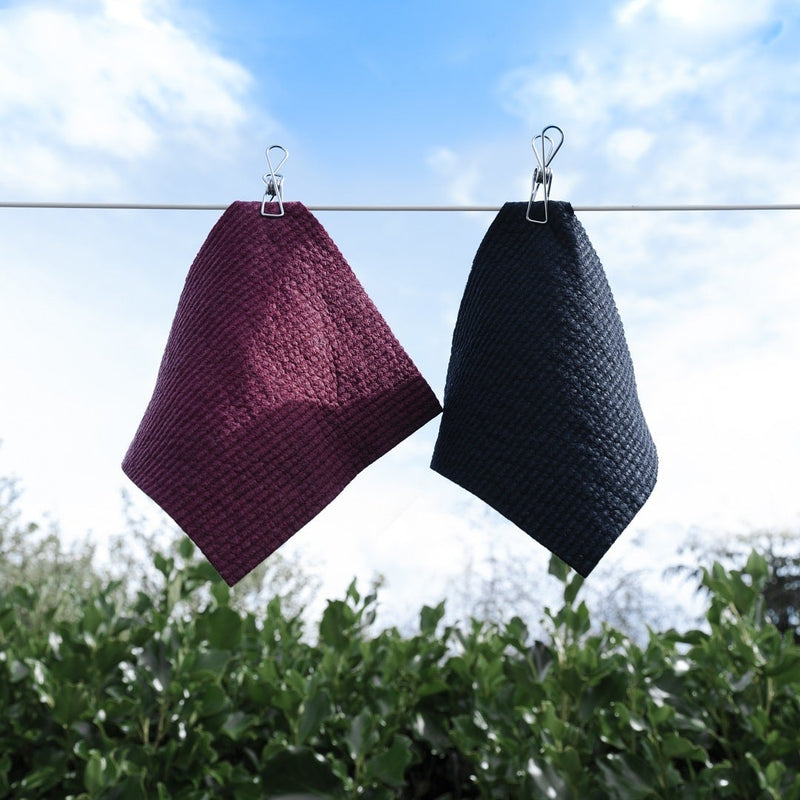 Two Good Change Swedish Dish Cloths - Black (2-PACK) hanging on a clothes line.