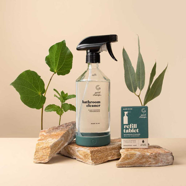 A bathroom reusable spray bottle of eco-friendly eucalyptus cleaner sits on top of rocks. (Brand name: Good Change)
