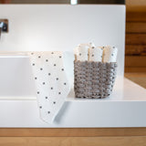 An eco-friendly bathroom sink with a basket of Good Change Reusable Bamboo Towels on it.