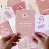 A group of people holding up cards with Collective Hub's Affirmations to Guide Your Journey Box Card Set.