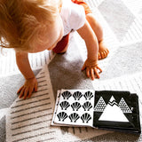 A baby is exploring a My Earth | Luxe Soft Cover Book by My Family Book.
