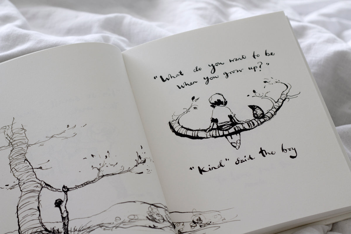 An open Charlie Mackesy | The Boy, The Mole, The Fox and The Horse book with a drawing of a tree and a bird.