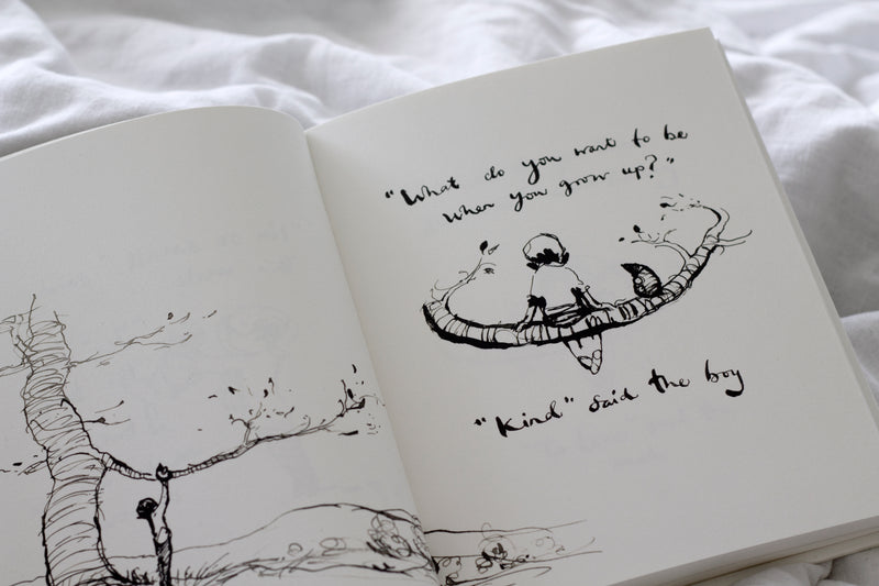 An open Charlie Mackesy | The Boy, The Mole, The Fox and The Horse book with a drawing of a tree and a bird.