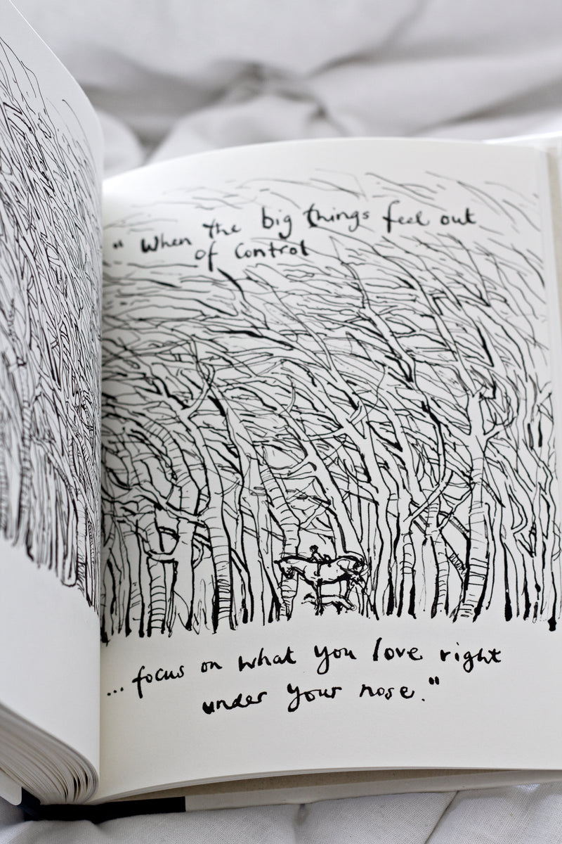 An open Charlie Mackesy | The Boy, The Mole, The Fox and The Horse book with a drawing of trees.