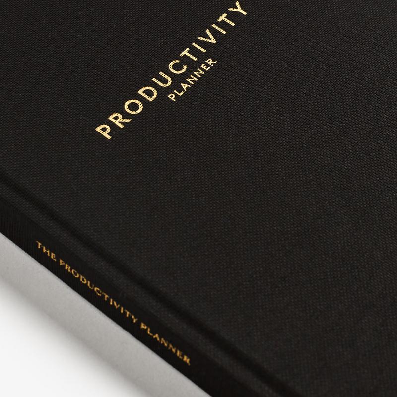 A black Productivity Planner book with the word Intelligent Change on it.
