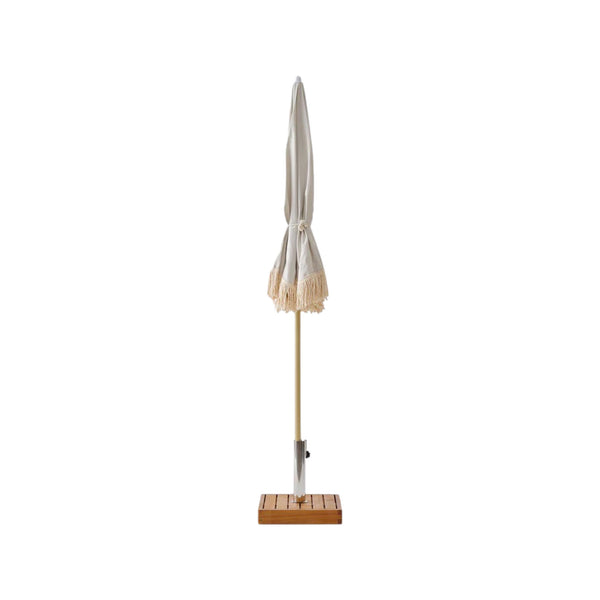 A Brel Club Fringe Umbrella - Palm Tree on a wooden stand.