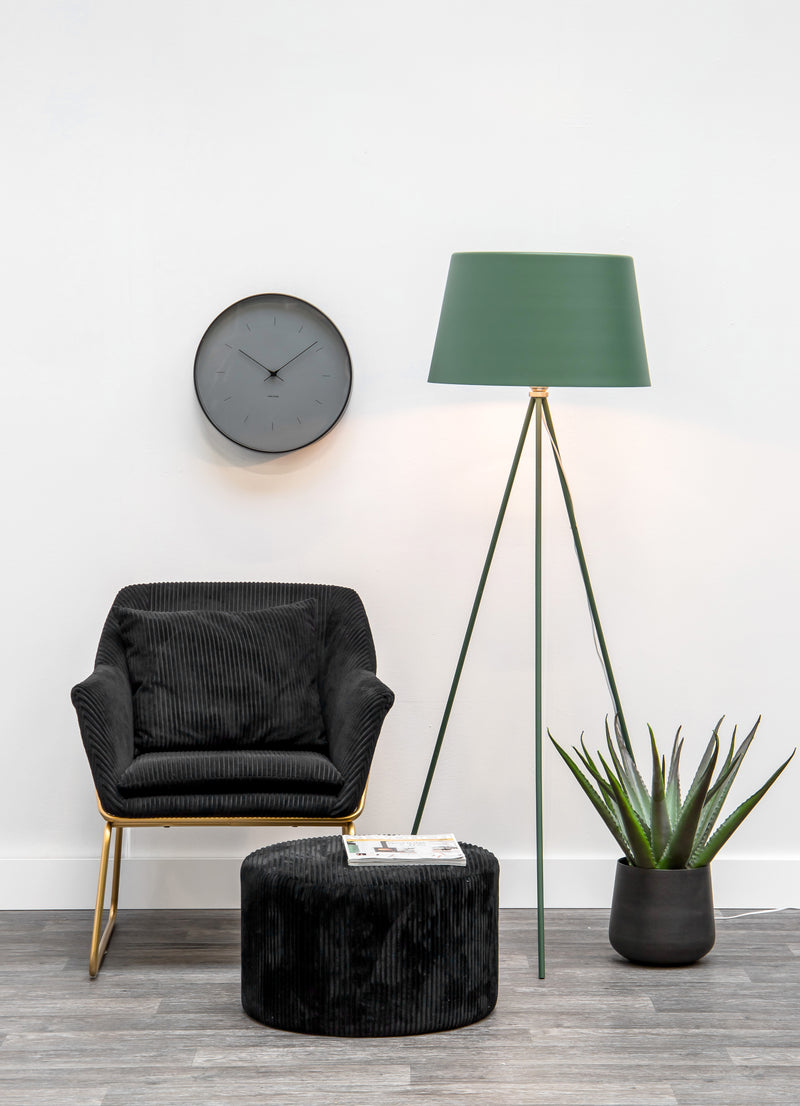 A black Karlsson wall clock with Scandinavian design in various sizes and colors, paired with a green lamp.