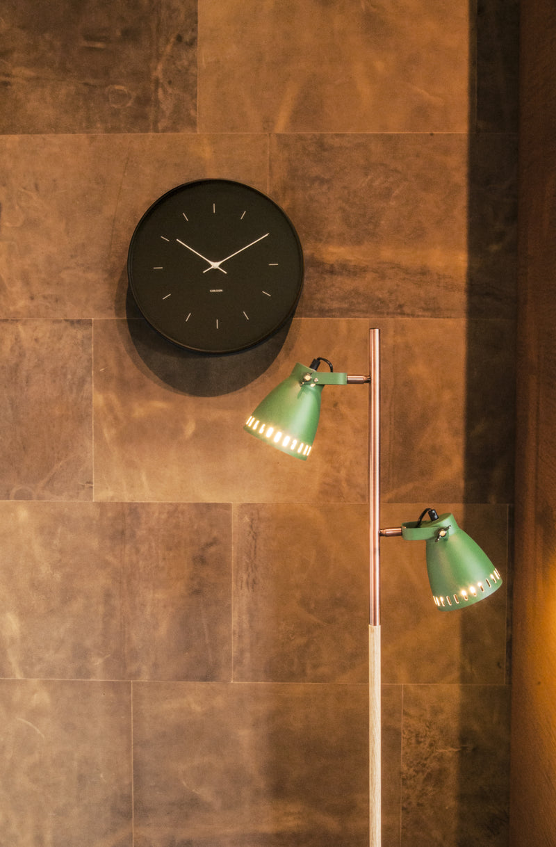 Aesthetic Karlsson Wall Clock with Minimalistic Design - Various Sizes / Colours, accompanied by a green lamp on the wall.