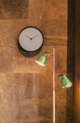 A Butterfly Hands Wall Clock - Various Sizes / Colours by Karlsson is next to a green lamp.