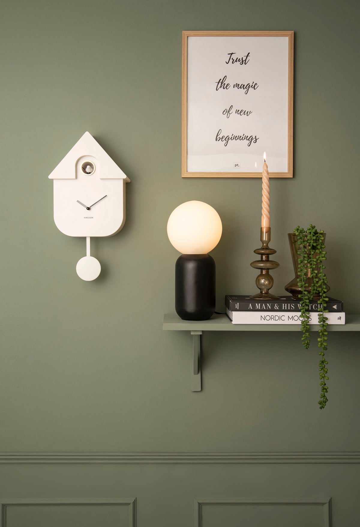 Karlsson Modern Cuckoo Clock styled on a wall beside a trailing plant