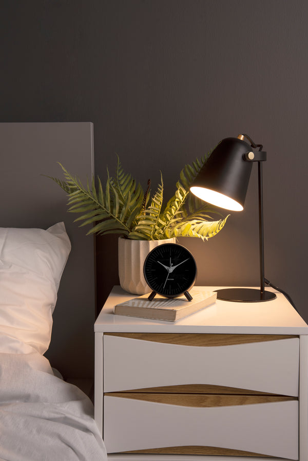 A Scandinavian-designed white nightstand by Karlsson featuring an aesthetic lamp and plant.