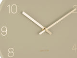 A Karlsson Charm Wall Clock with engraved gold numbers on a beige background.
