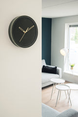A Karlsson Lush Velvet Wall Clock - Grey (30cm) in a living room.