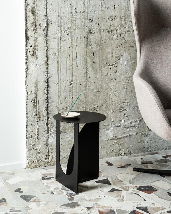 An Arch Side Table ∙ Black from Made of Tomorrow in front of a tiled floor.