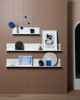 A room with a FOLD Display Ledge 1200mm ∙ White shelf and a brown wall. (Brand: Made of Tomorrow)