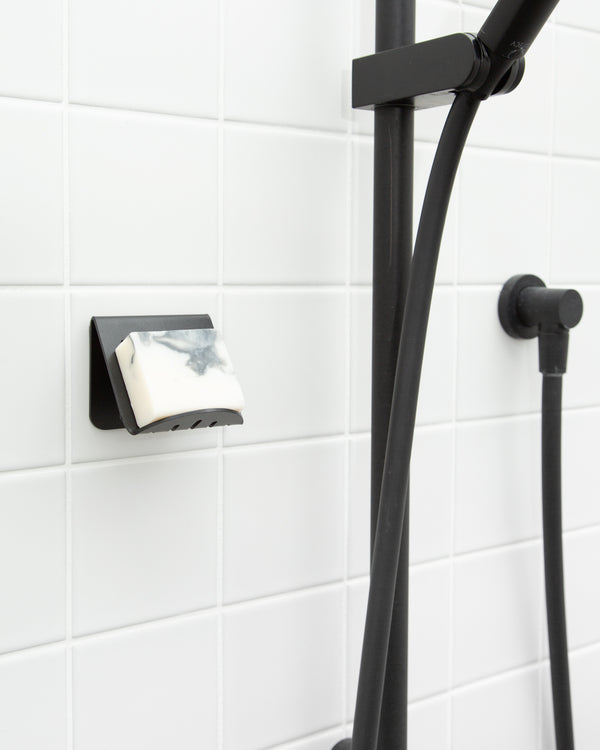 A FOLD Soap Block Holder ∙ Black made by Made of Tomorrow with a soap dispenser attached to it.