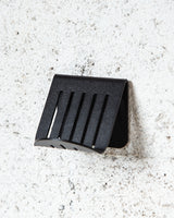 A FOLD Soap Block Holder ∙ Black hanging on a concrete wall made by Made of Tomorrow.