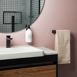 A bathroom with pink walls and a Made of Tomorrow FOLD Bottle Holder ∙ White sink.