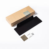A black box containing a business card, featuring Made of Tomorrow's FOLD Ledge 900mm ∙ Black for organizing kitchen objects or bathroom essentials.