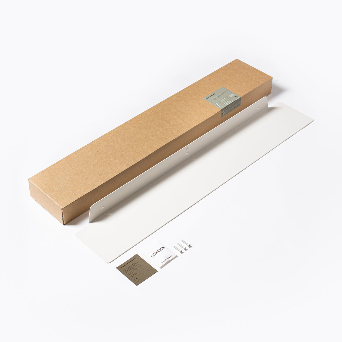 A Made of Tomorrow cardboard box filled with FOLD Ledge 900mm ∙ White kitchen objects.