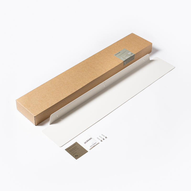 A Made of Tomorrow cardboard box filled with FOLD Ledge 900mm ∙ White kitchen objects.