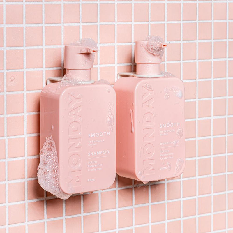 Two white FOLD Bottle Holder ∙ White bottles of soap on a tiled wall, made by Made of Tomorrow.