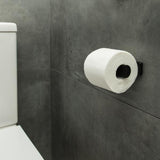 A bathroom with a FOLD Toilet Roll Holder ∙ Black by Made of Tomorrow on the wall.