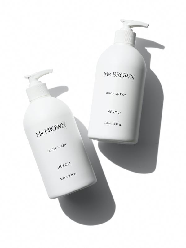 Two bottles of Ms Brown Neroli body lotion on a white surface.